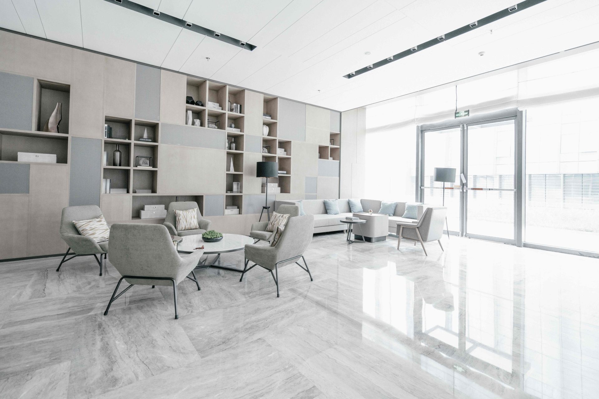 Intérieur d’un salon avec canapés, assises et un sol en marbre gris.